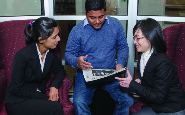 Capital Community College Students looking at newspaper