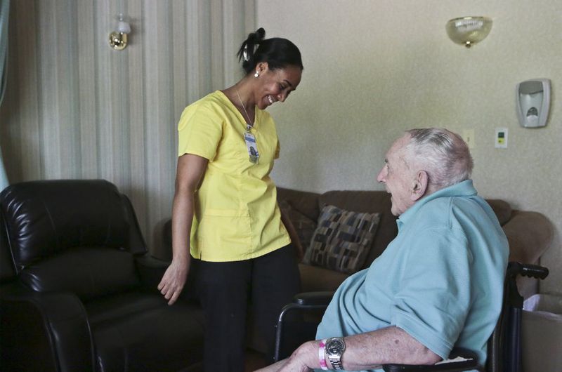 Certified Nursing Assistant Ellen Tadese shares a light moment with Omer Gaudreau, a resident at Manchester Manor Health Care Center. (Michael McAndrews/Special to The Courant)